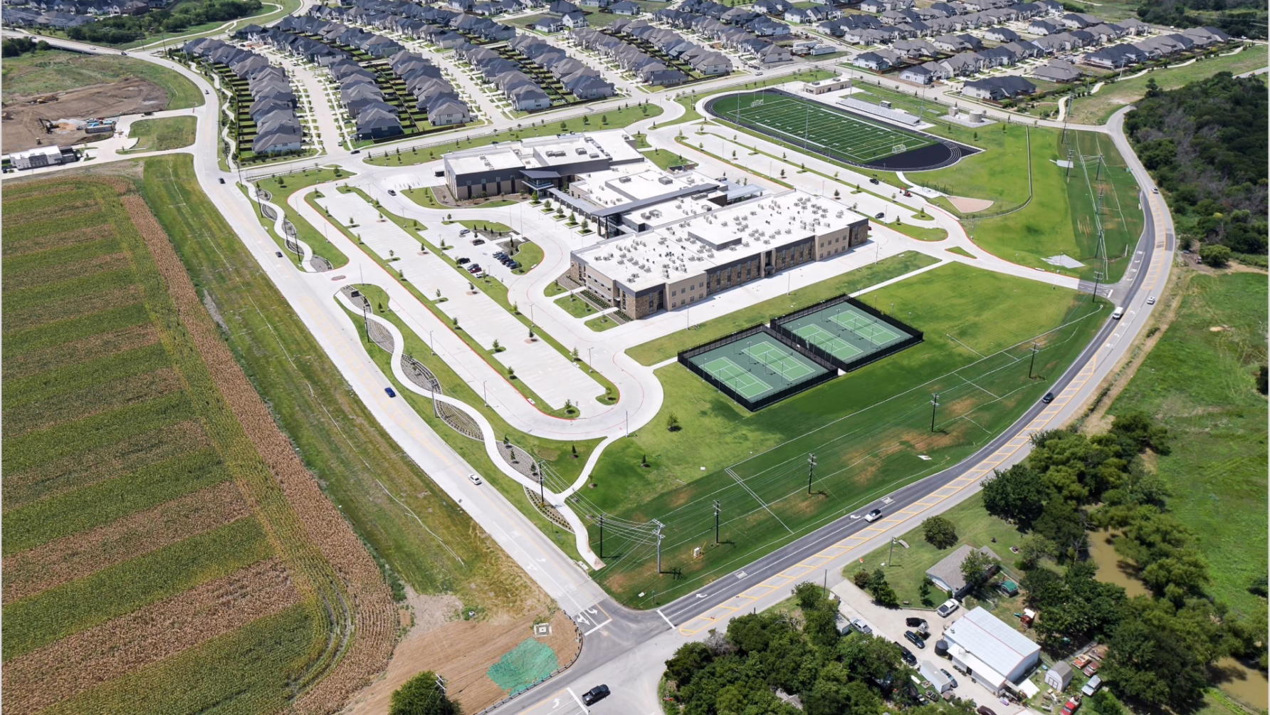 Aerial view of Prosper Middle School #6 with sports fields, parking lots, and surrounding residential area.